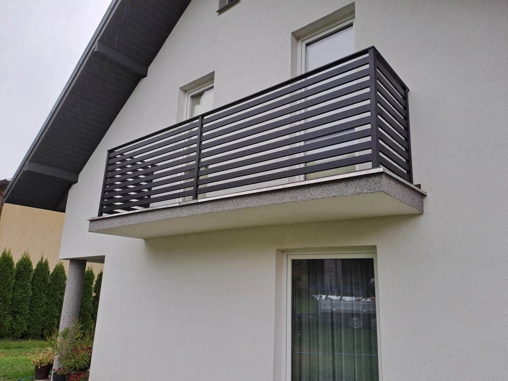 Balustrady balkonowe z poziomymi czarnymi metalowymi elementami na jasnej elewacji domu