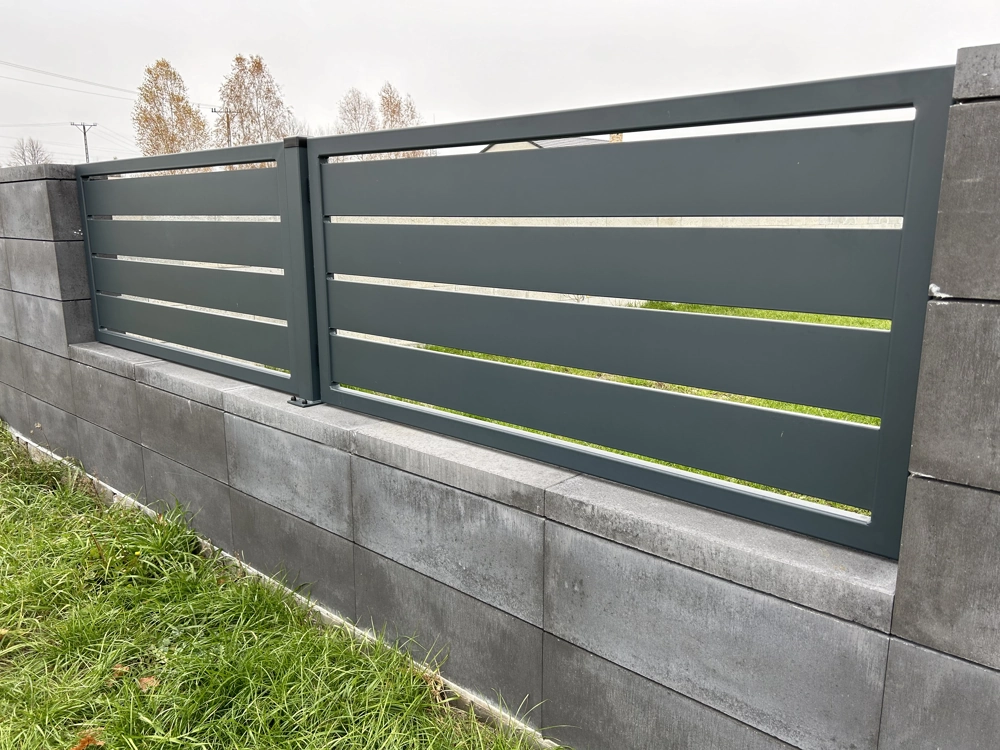 Ogrodzenie aluminiowe z poziomych profili osadzone na murku z bloczków betonowych
