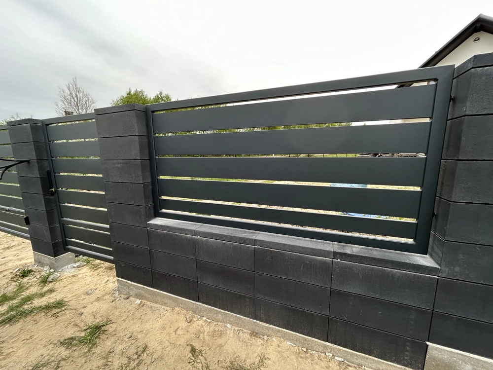 Ogrodzenie żaluzjowe z czarnych poziomych profili na murku z bloczków betonowych